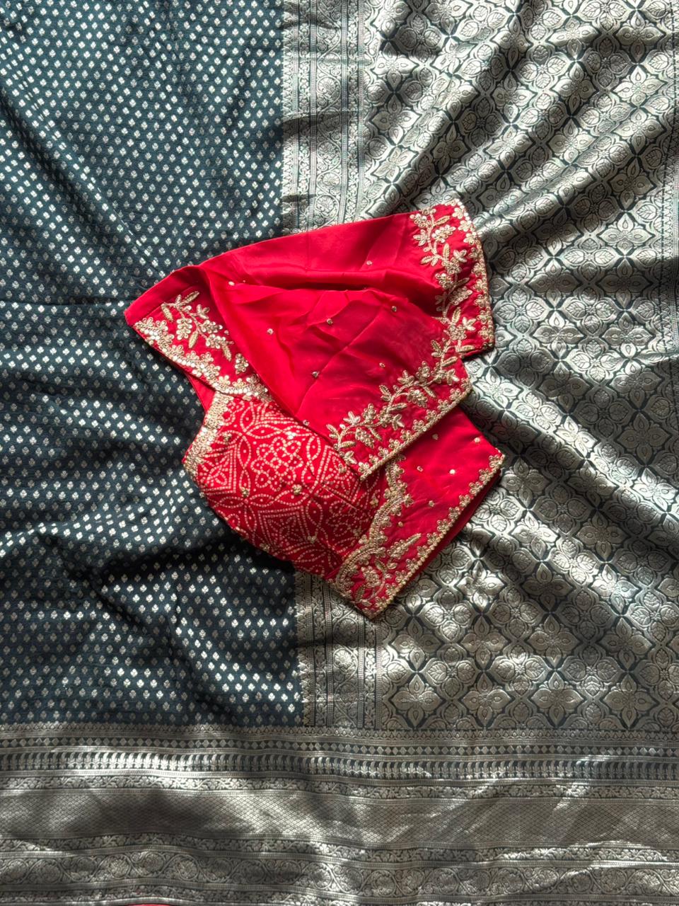 Red embroidered fabric on a textured silver surface